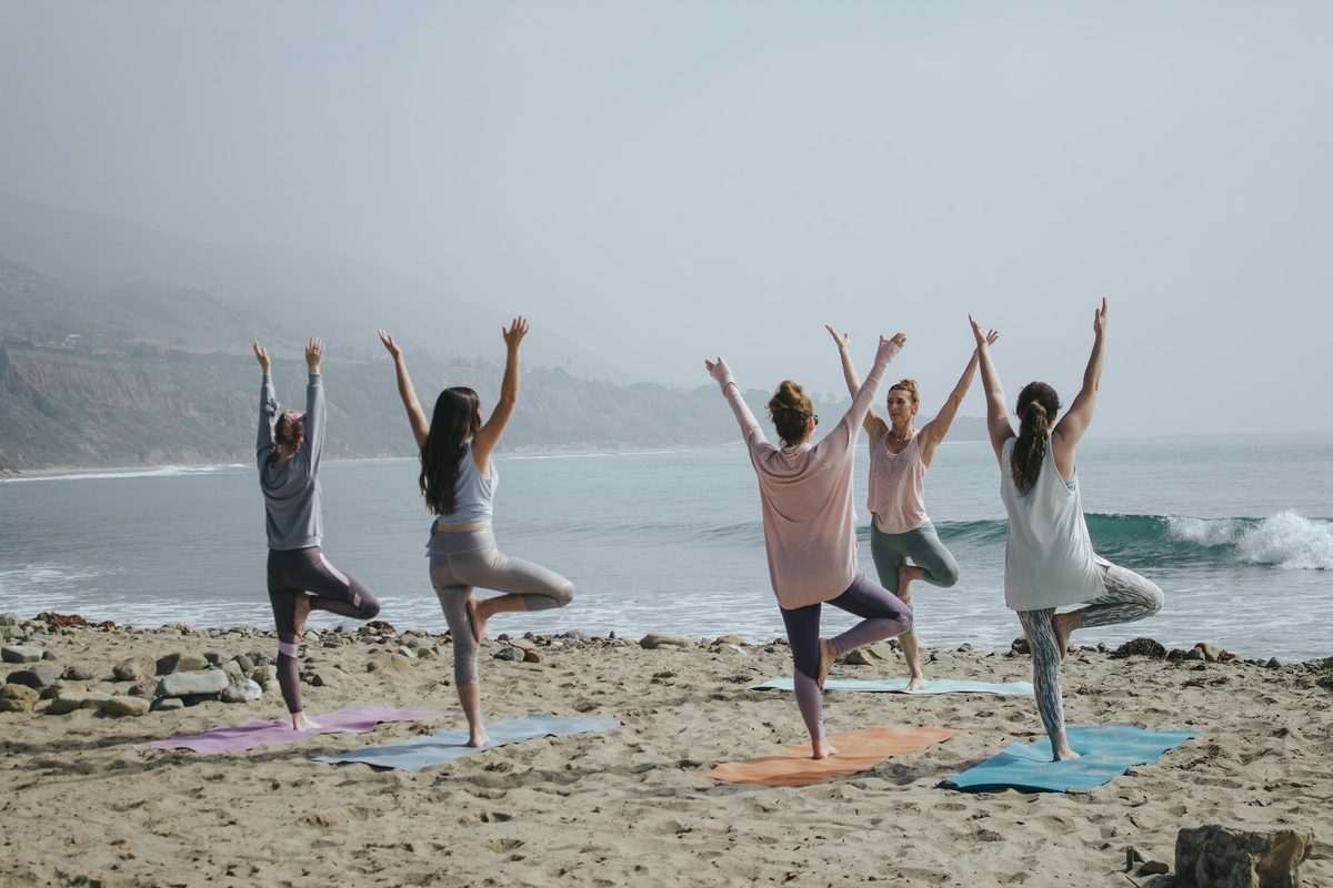 A group doing yoga on the beach