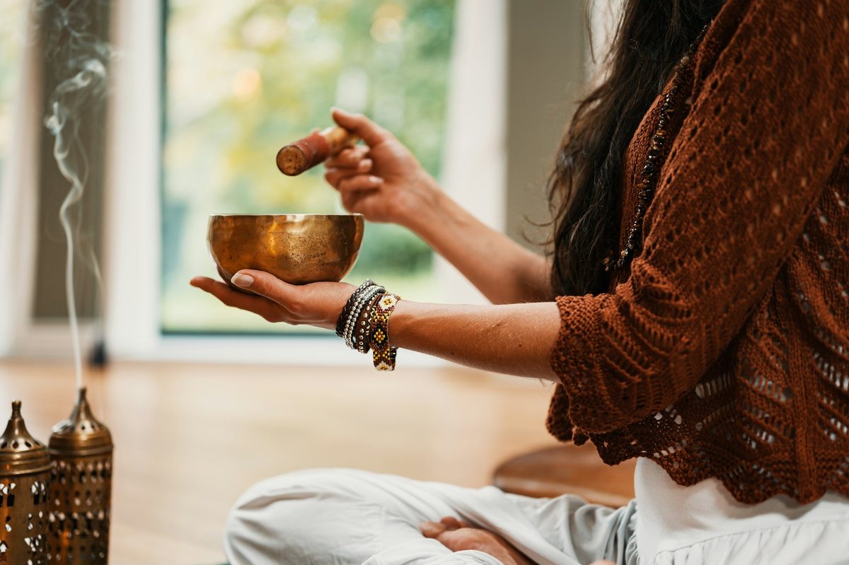A woman playing a singing bowl